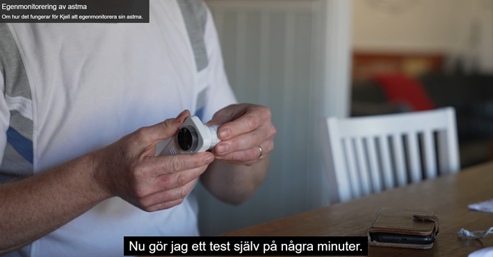 Bilden visar Kjell som använder egenmonitorering för att hålla koll på sin astma och lungkapacitet. Kjell är i sitt hem och beskriver att det med egenmonitorering är enkelt för honom att själv testa sin lungkapacitet på några minuter hemma.